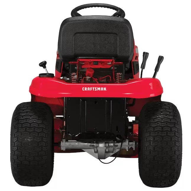 Craftsman T100 riding lawn mower with 11.5 HP engine, featuring a wide cutting deck and comfortable seat in a lush green yard.