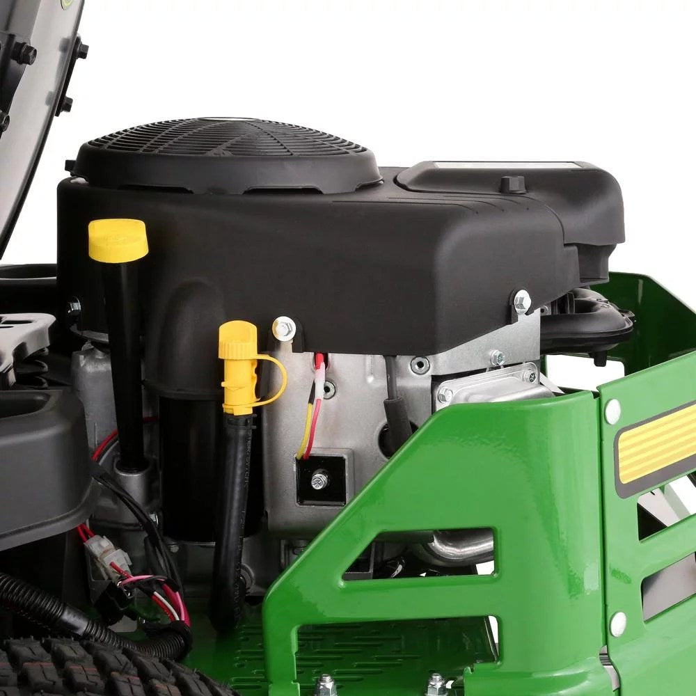 John Deere Z345M zero-turn riding mower with gas engine and dual hydrostatic drive, shown cutting grass in a lush yard.